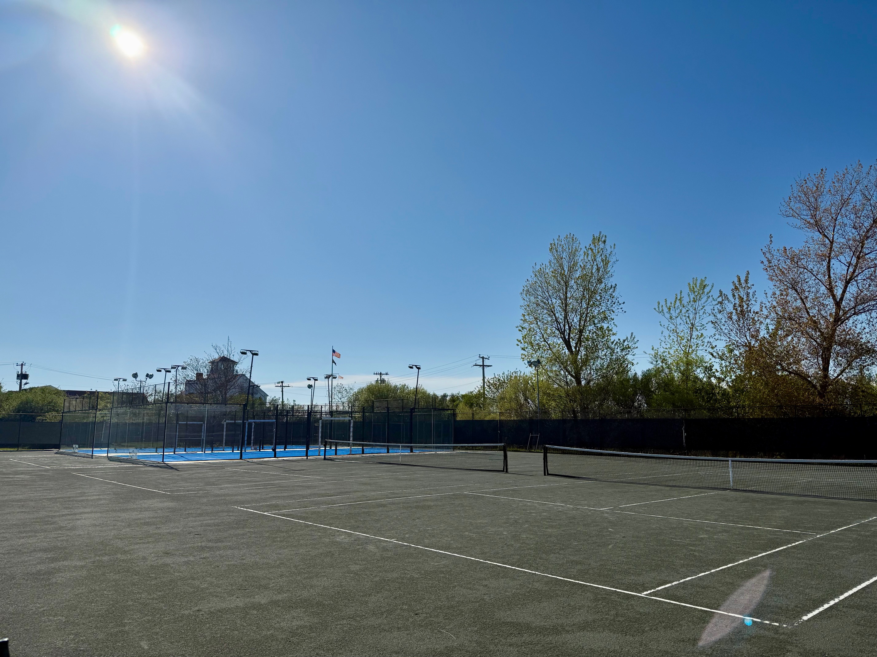 a tennis court with net and trees in the background