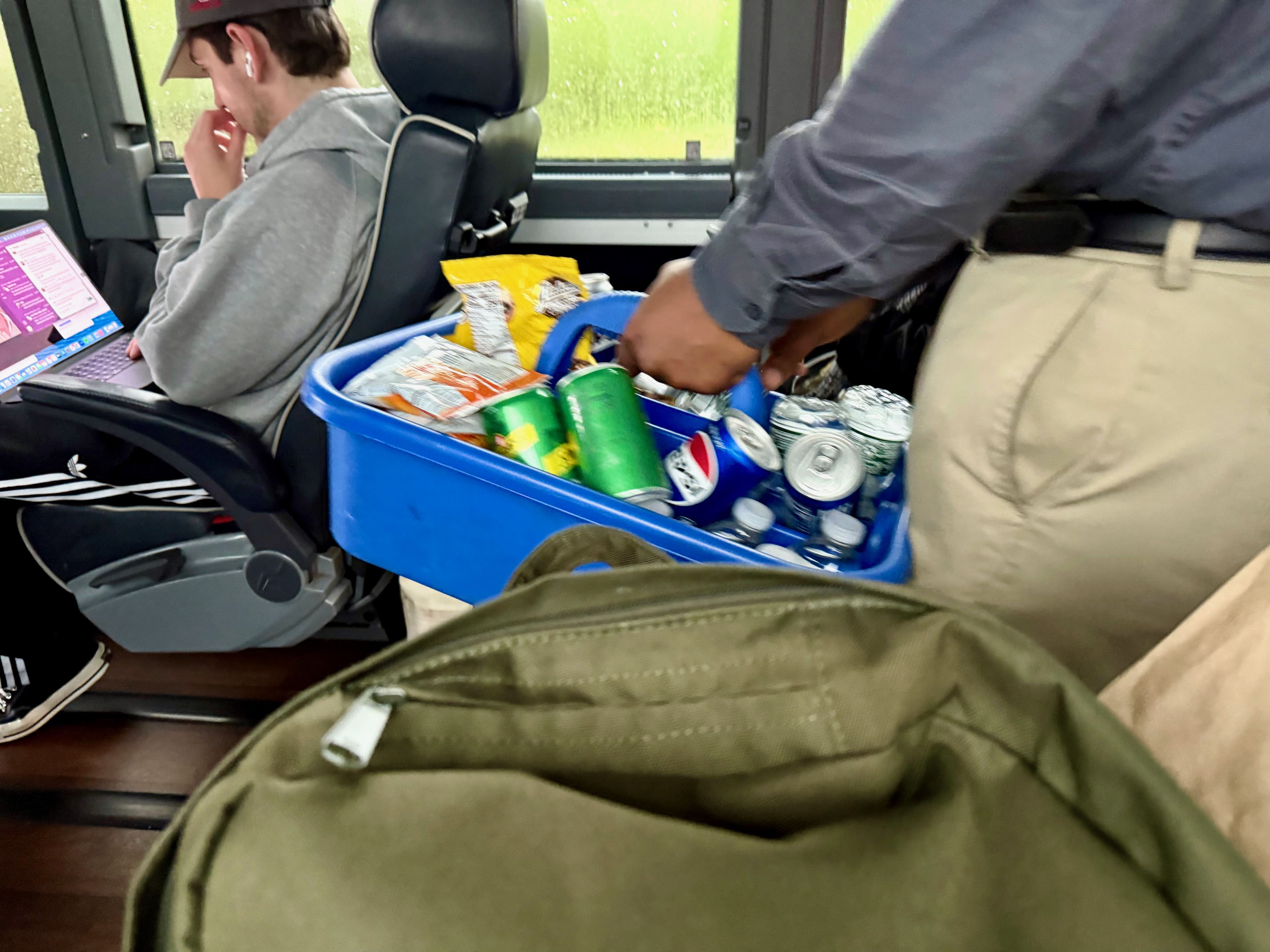a man holding a blue basket full of drinks