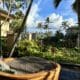 a chair on a deck with palm trees and a blue sky at the Ritz Carlton Maui