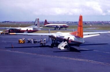 a group of people standing next to a plane