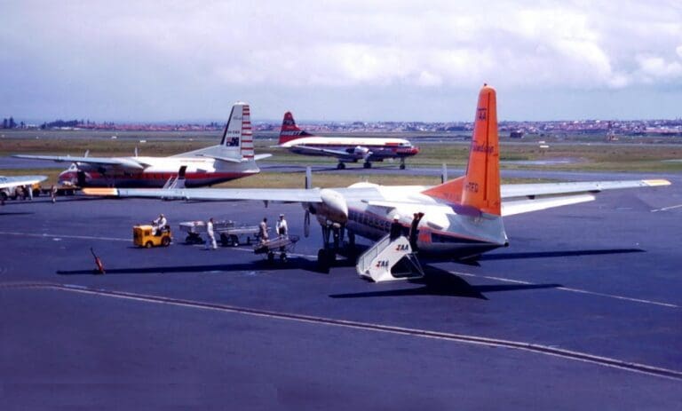 a group of people standing next to a plane