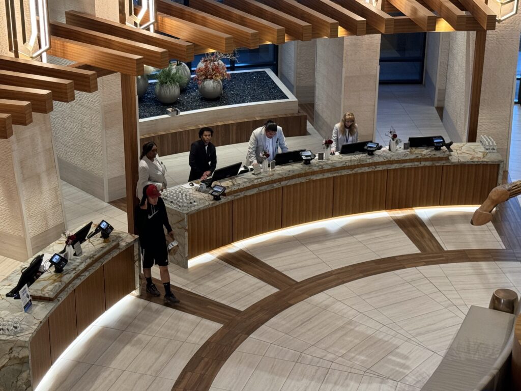 a group of people standing at a counter in a hotel