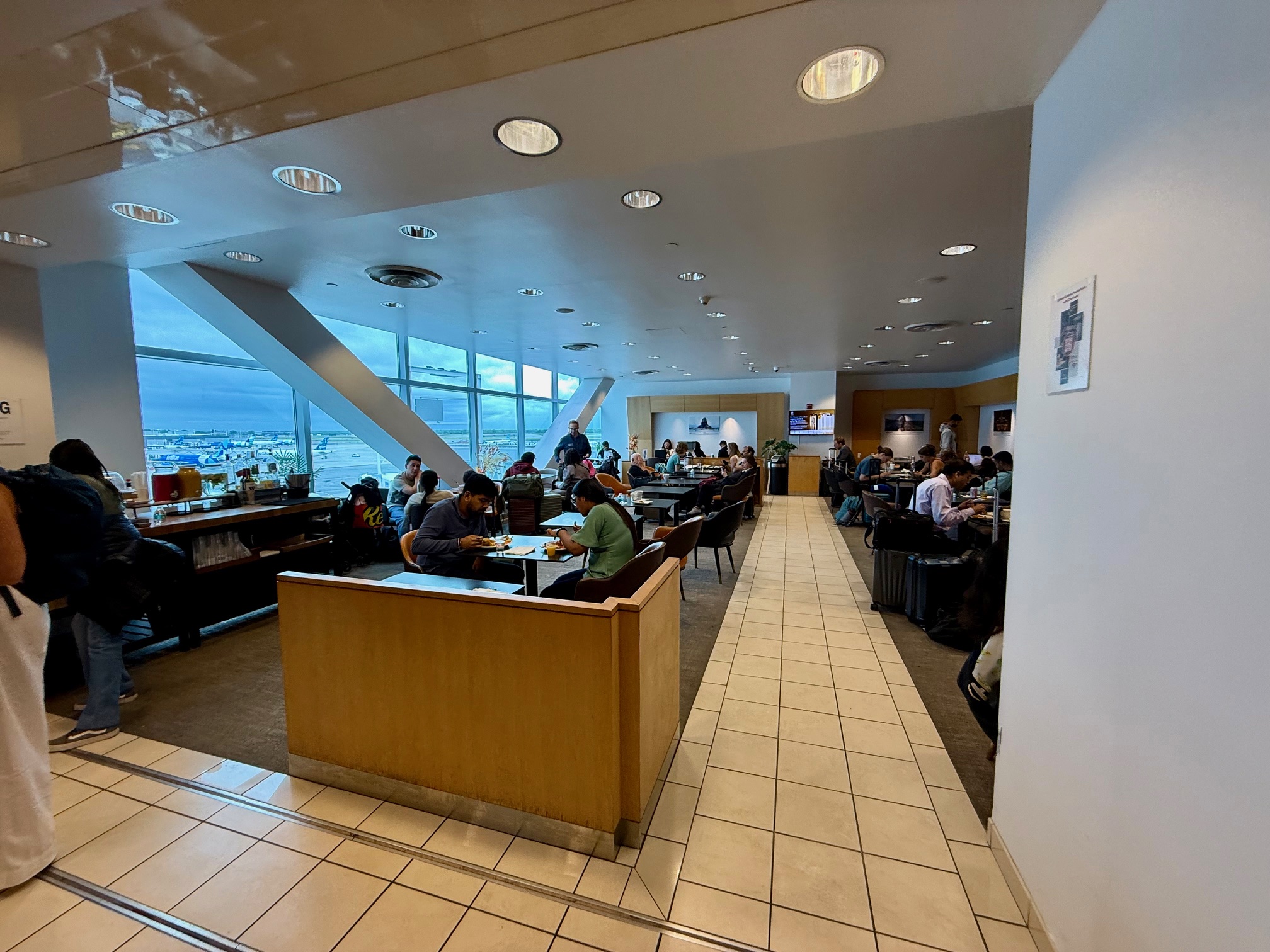 a group of people sitting at tables in a room with large windows