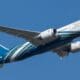 a blue and white airplane in the sky