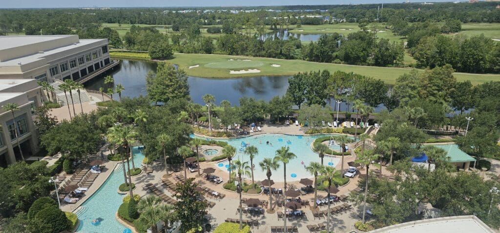 a pool with palm trees and a golf course