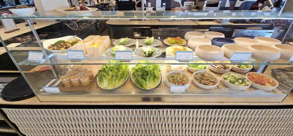 a display case with salads and bowls of food