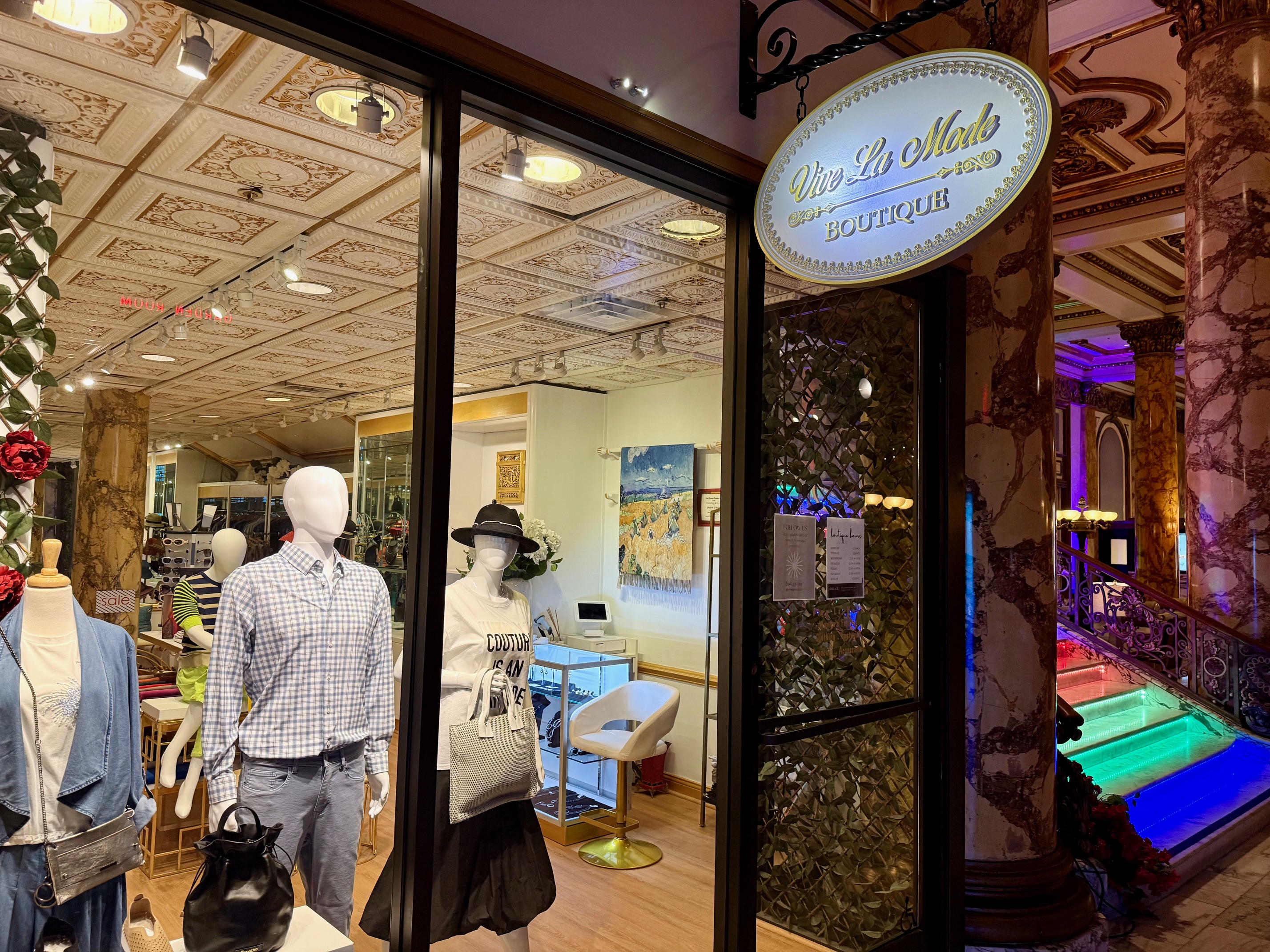 a store front with mannequins and a sign