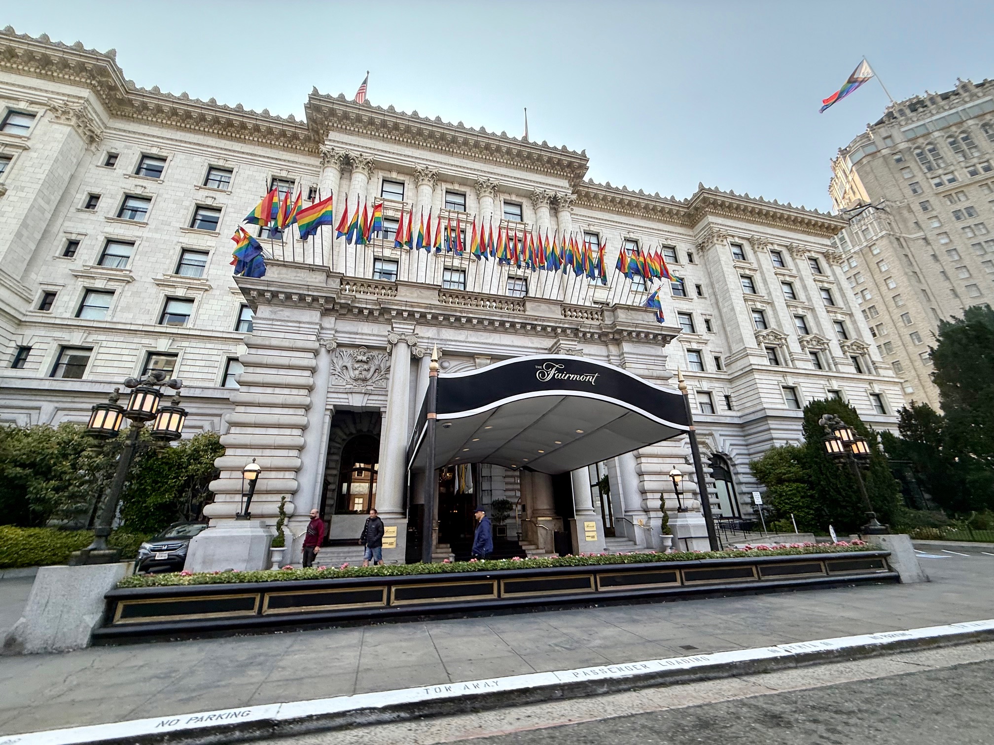 a large white building with flags on the front of the Fairmont San Francisco