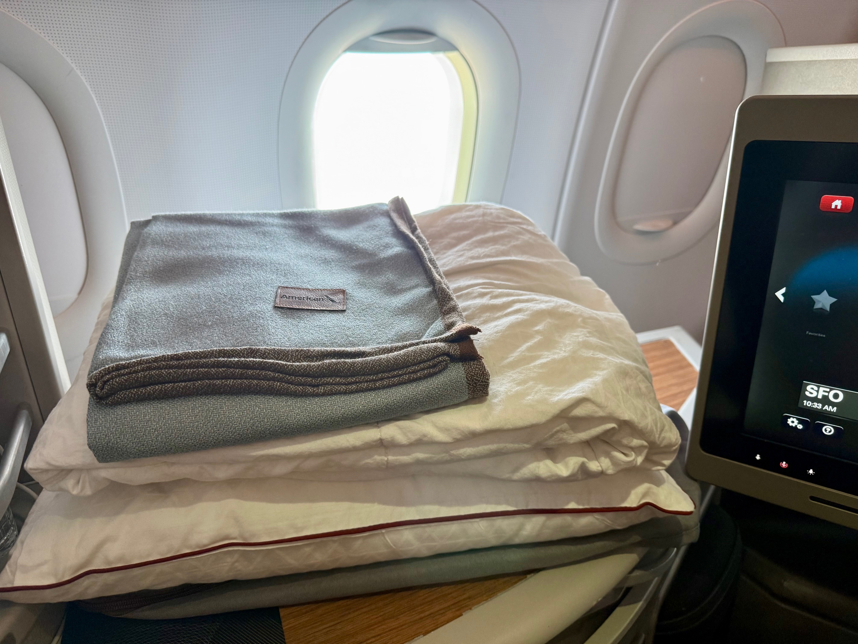 a stack of blankets on a plane on American Airlines Flagship First San Francisco