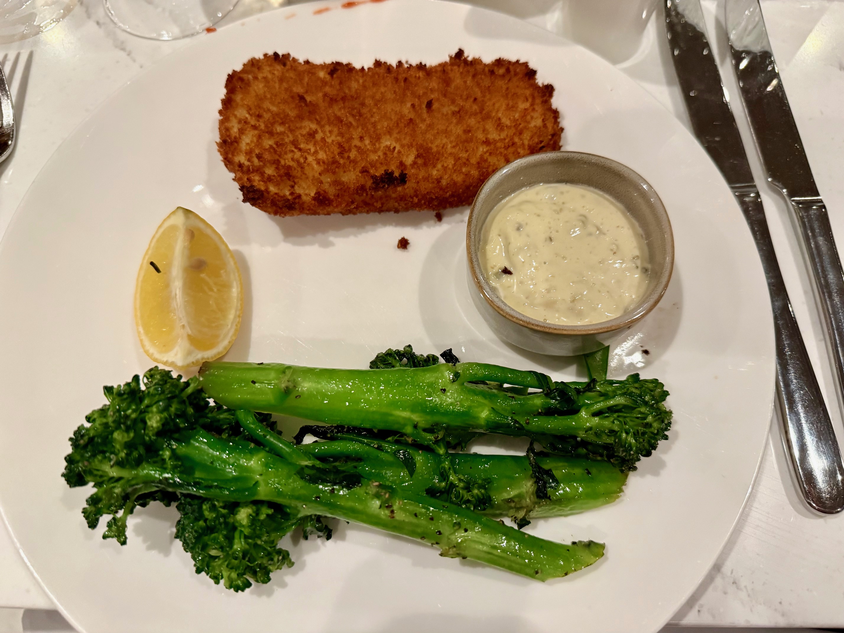 a plate of food with a lemon wedge and broccoli