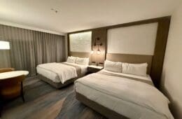 a room with two beds and a table at the Westin Sacramento Riverfront