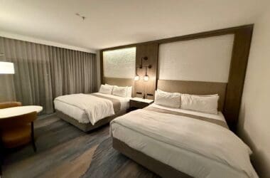 a room with two beds and a table at the Westin Sacramento Riverfront