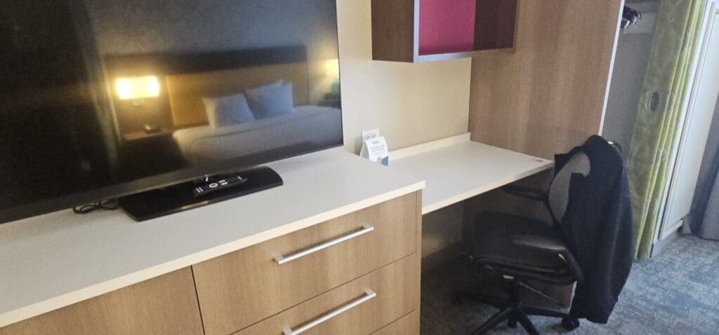a desk with a television and a chair