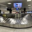 a baggage claim area with a television and a screen
