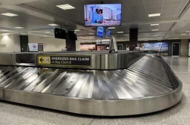 a baggage claim area with a television and a screen