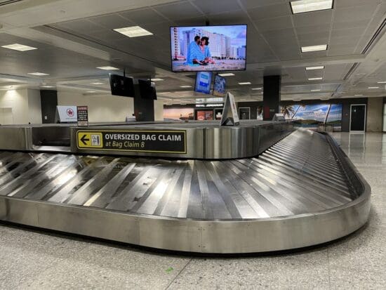 a baggage claim area with a television and a screen