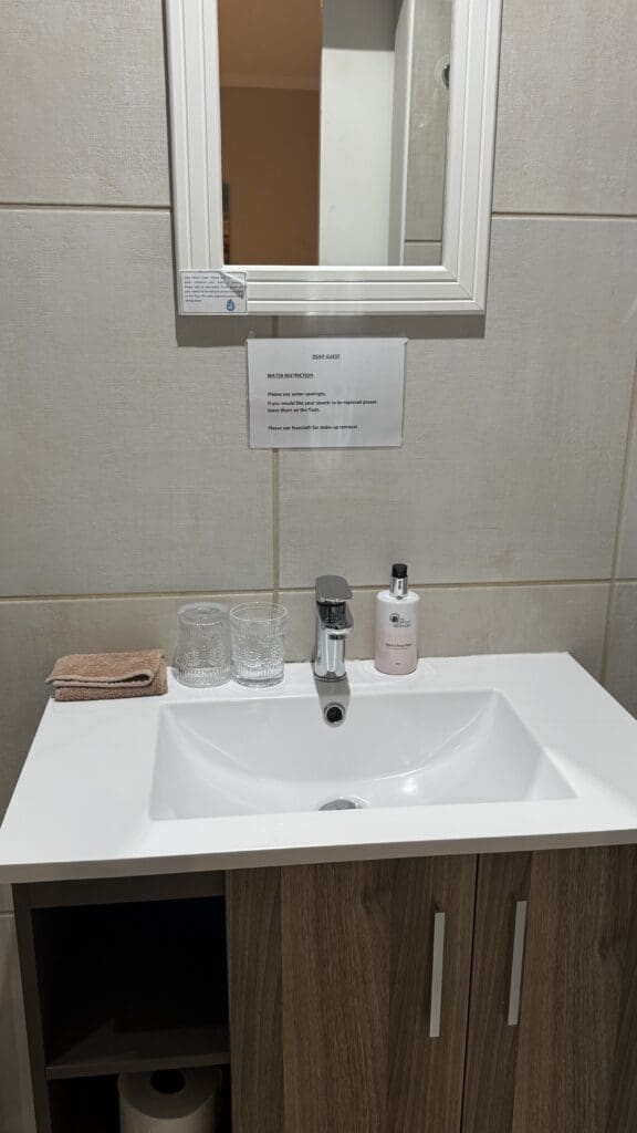 a sink with a mirror and a sign