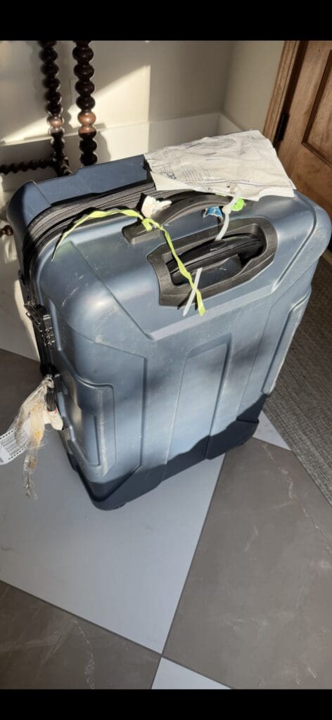 a suitcase with a handle and tape on it