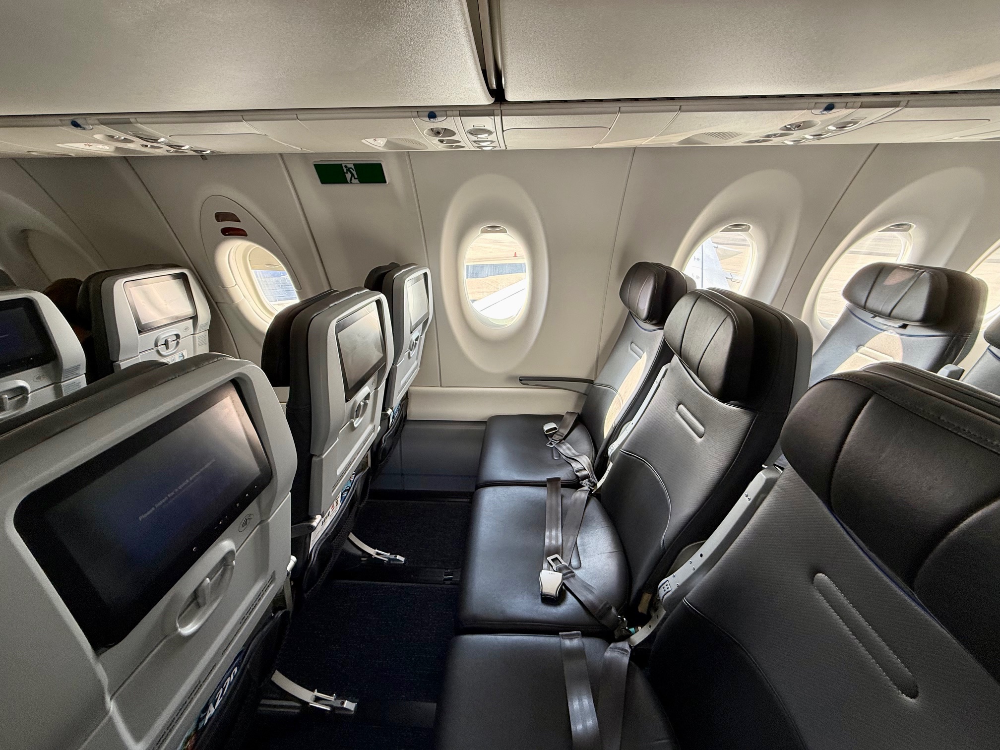 seats in an airplane with windows on the JetBlue Airbus A220