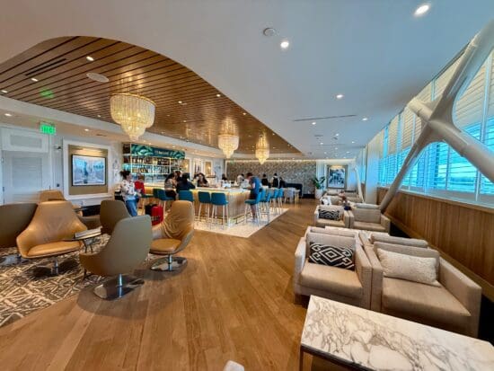 a room with a bar and chairs at the Primeclass Lounge Bermuda Airport