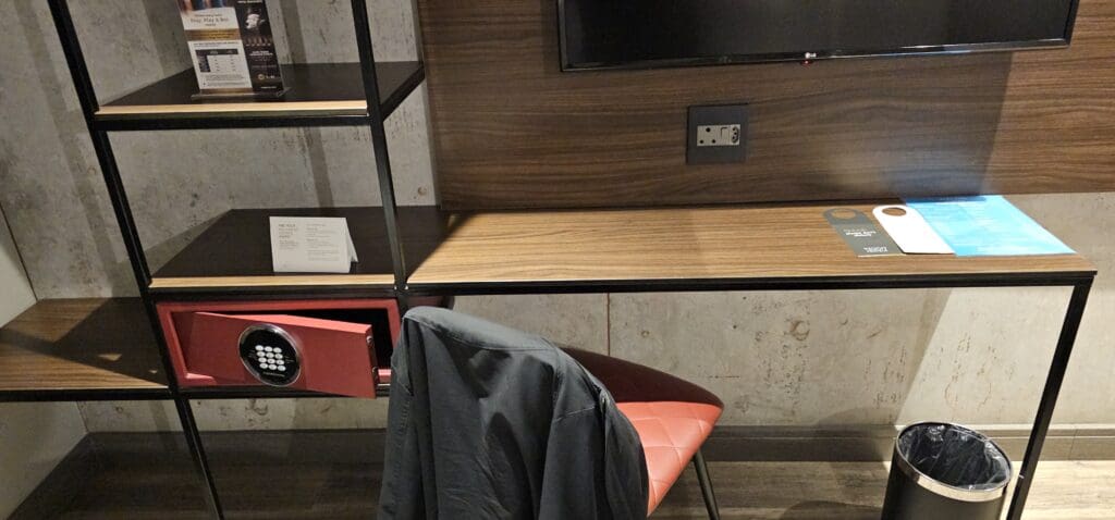 a chair and a desk with a red chair and a red chair with a red chair and a black shelf with a black box and a black door