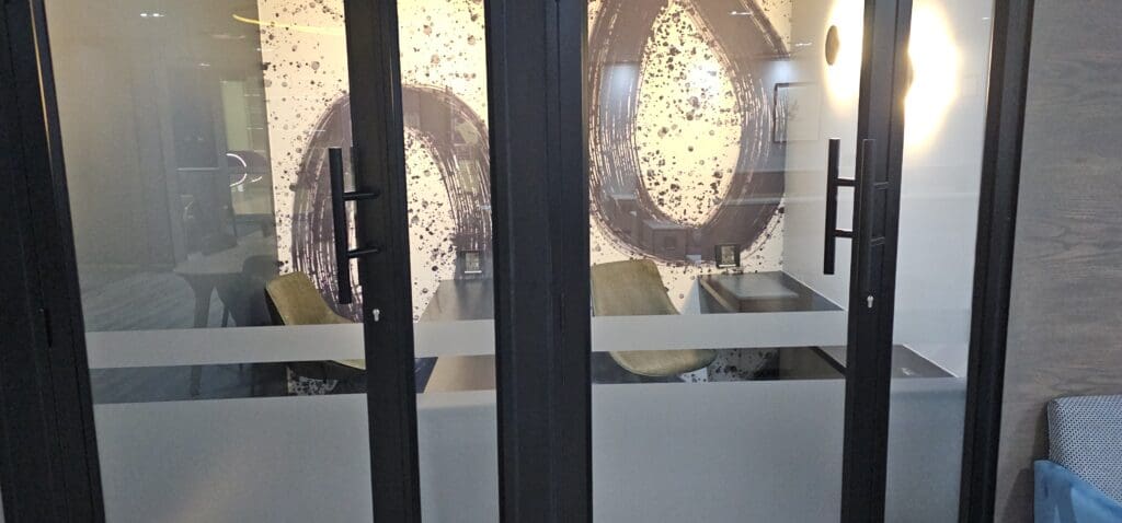a glass door with a picture of a desk and chairs