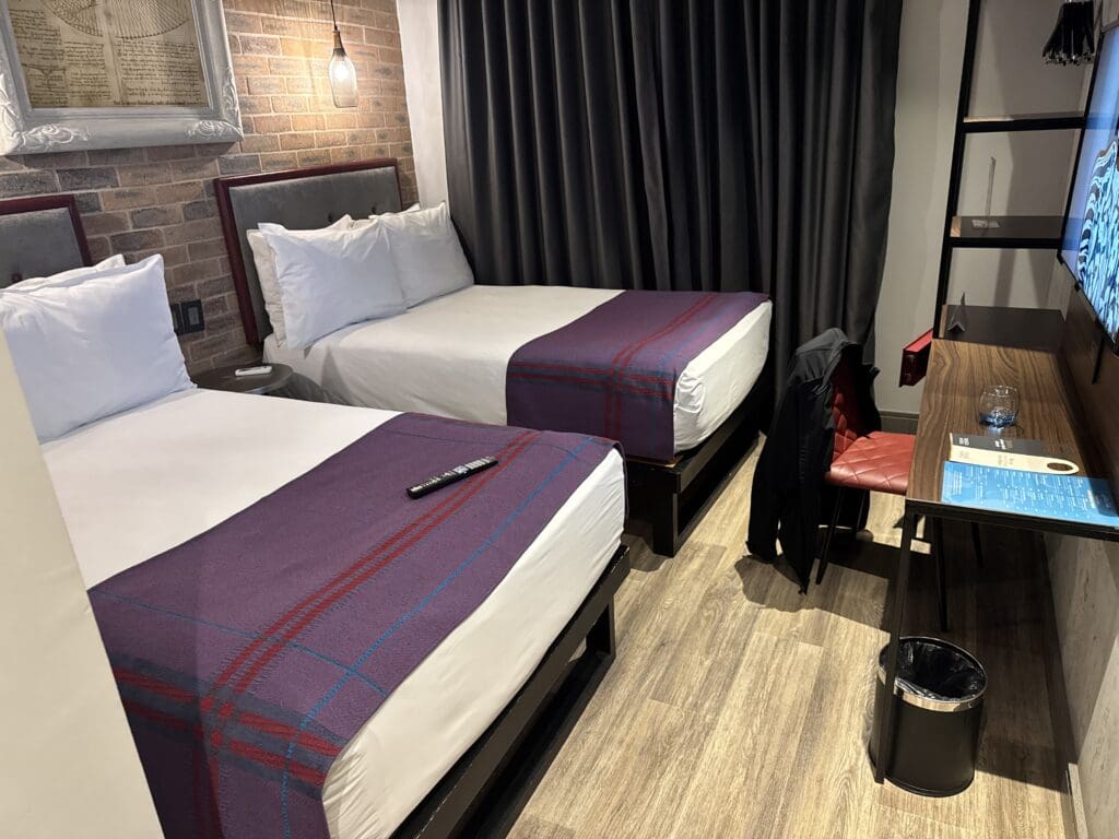 a room with two beds and a desk