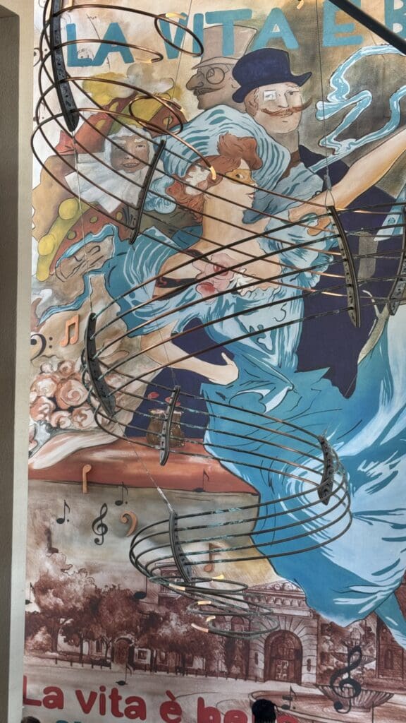 a mural of a woman with musical instruments from a ceiling