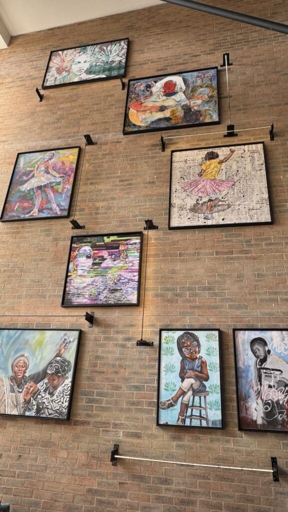 a group of framed pictures on a brick wall