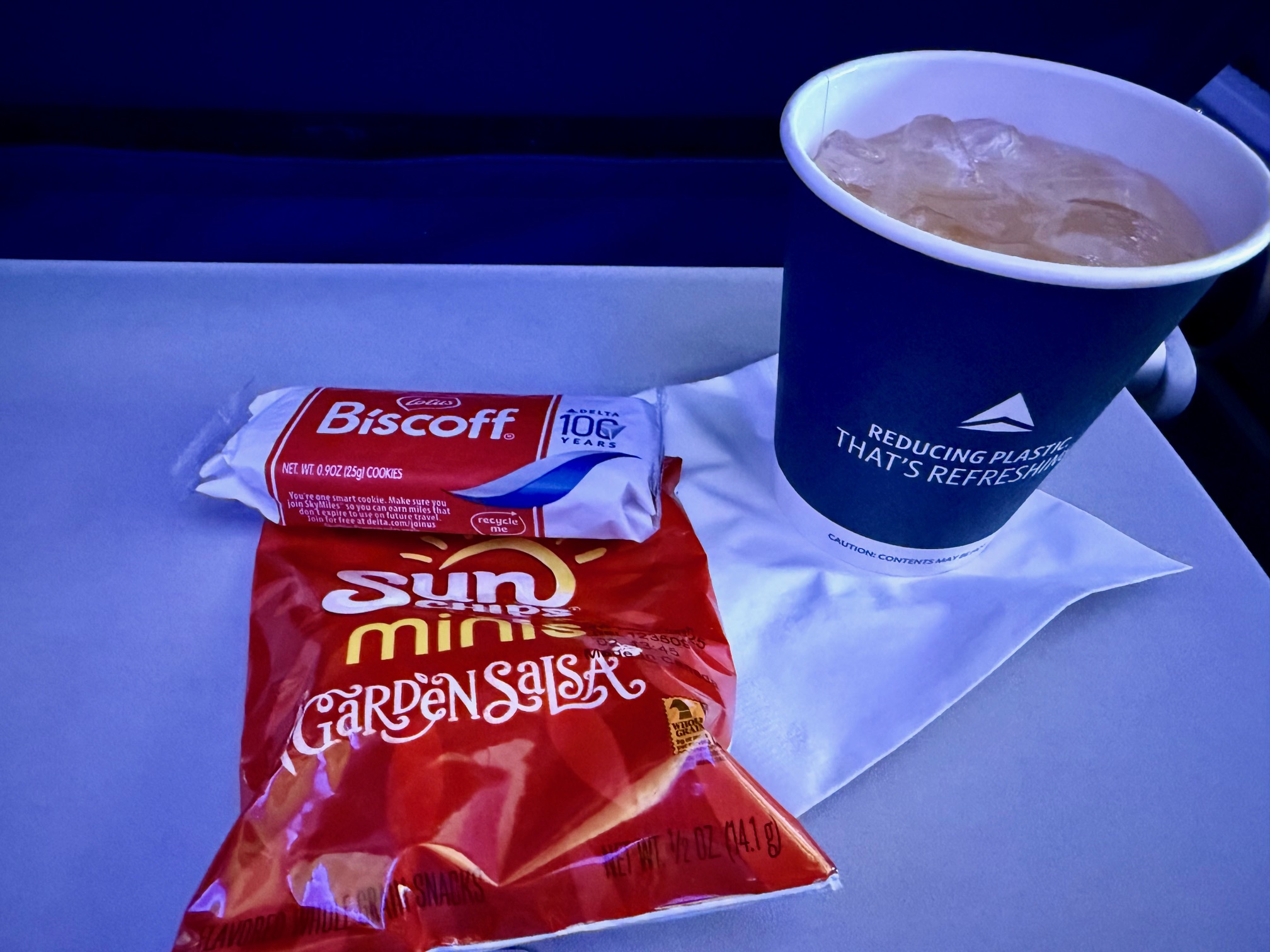 a cup of ice tea and a packet of chips on a Delta Main Cabin 767-300 flight