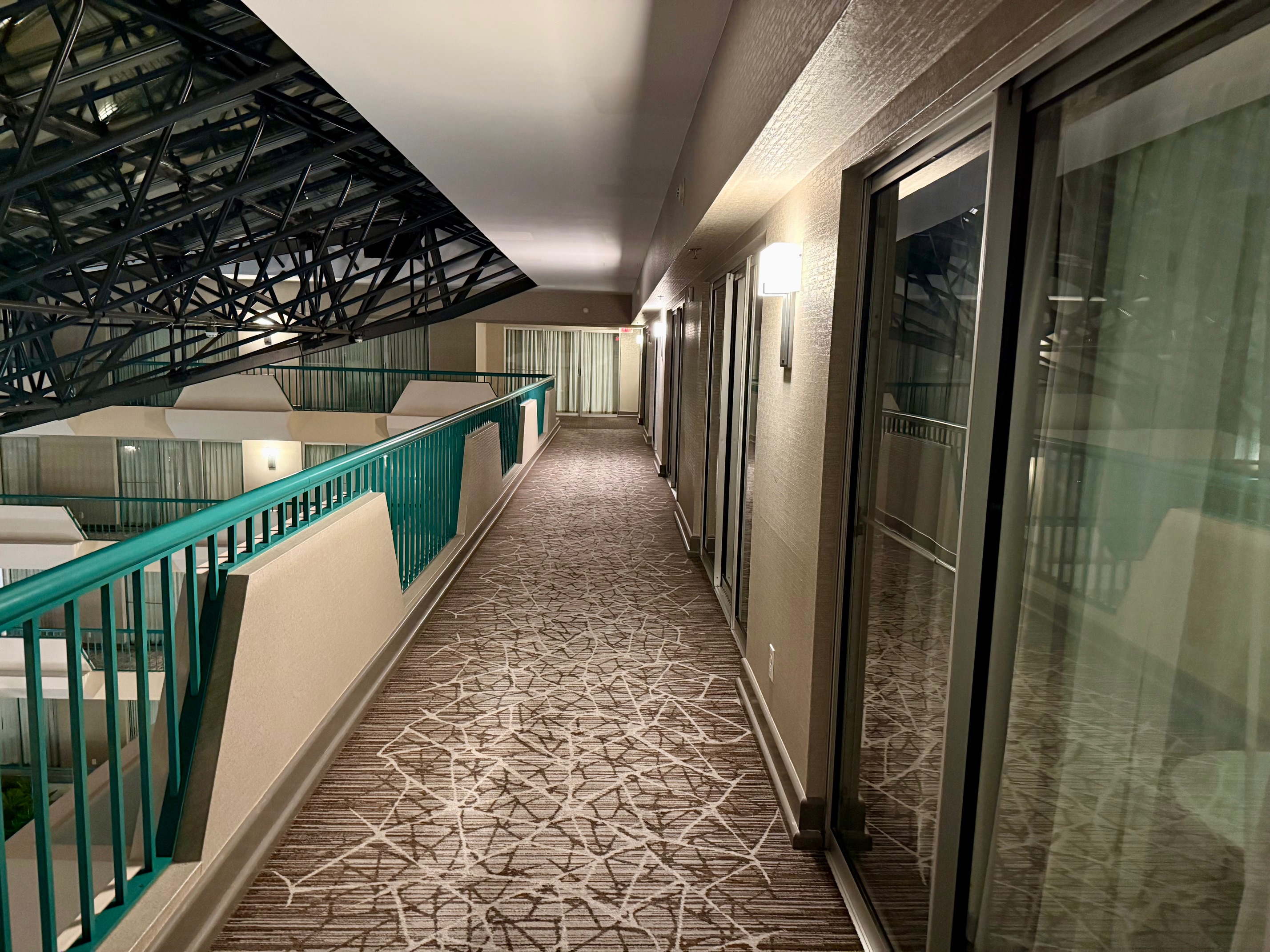 a hallway with glass doors and a railing
