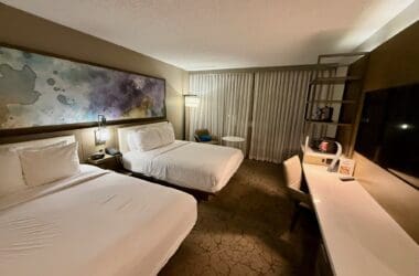 a room with two beds and a desk at the Marriott Melville Long Island