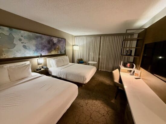 a room with two beds and a desk at the Marriott Melville Long Island