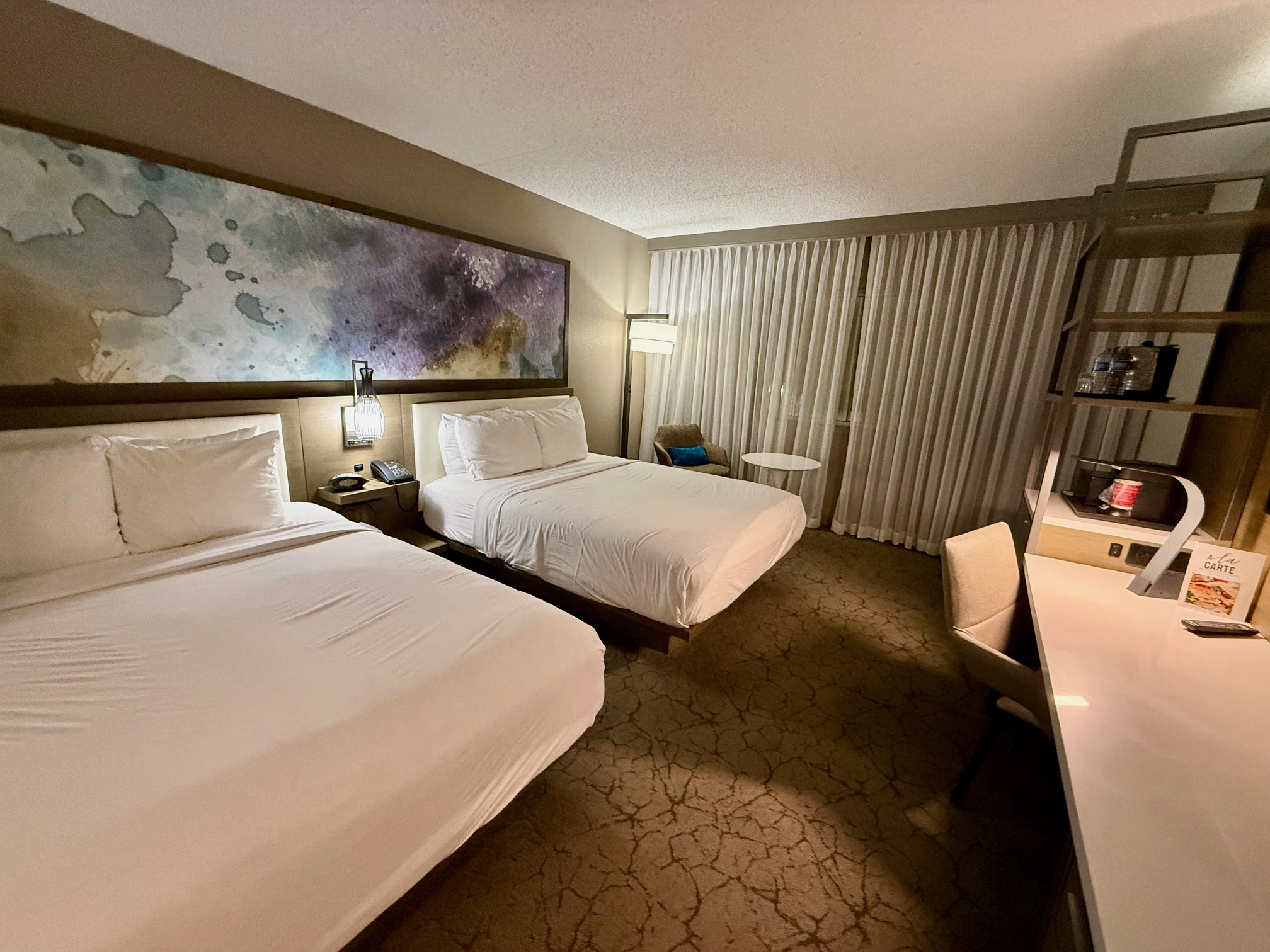 a room with two beds and a desk at the Melville Marriott Long Island