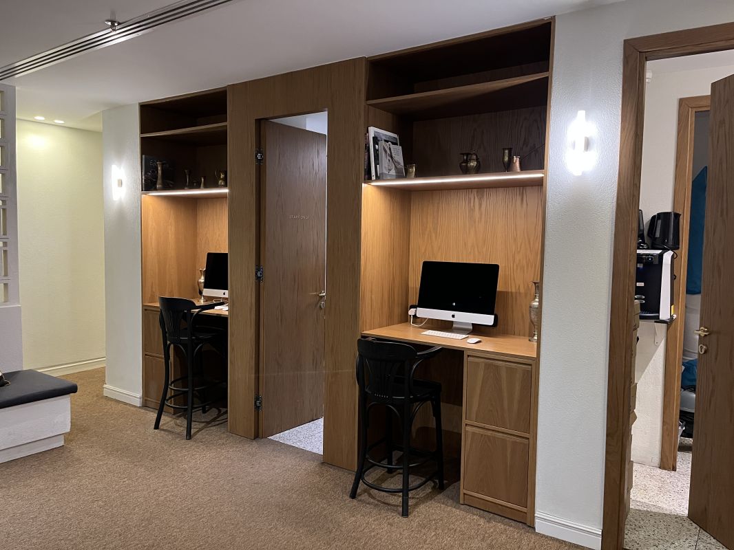 a desk with a computer and chairs in a room