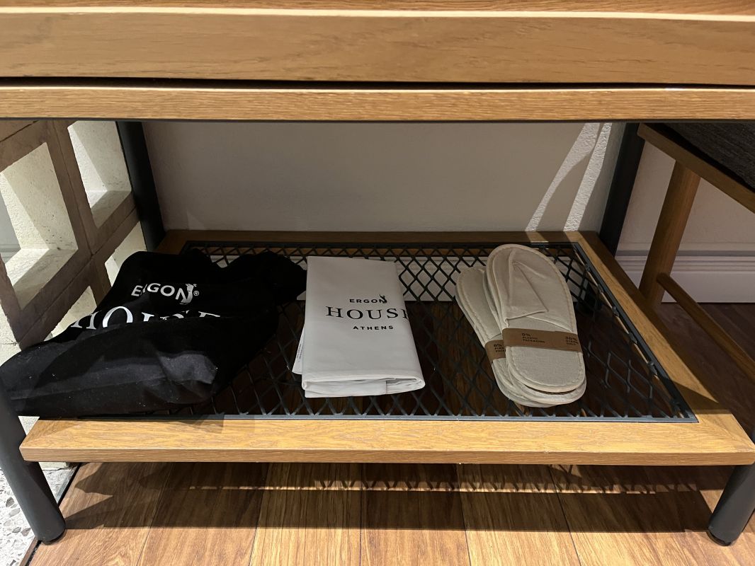 a shoe rack with slippers and a bag on it