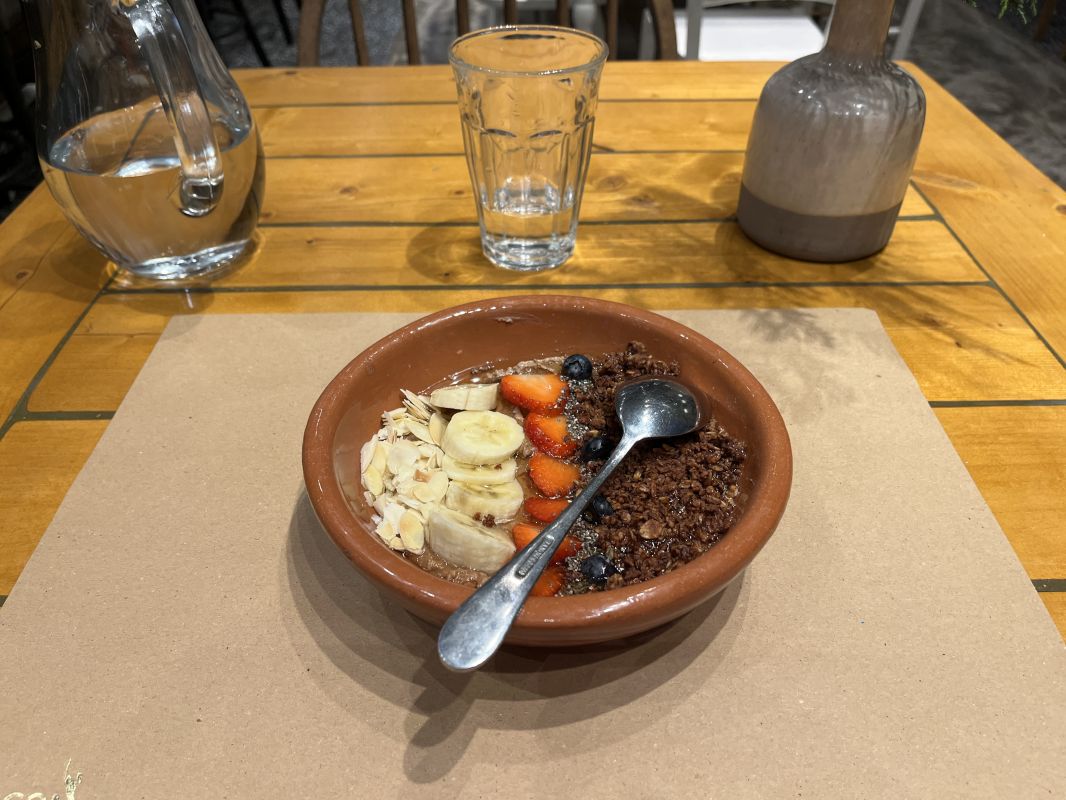 a bowl of oatmeal with fruit and a spoon