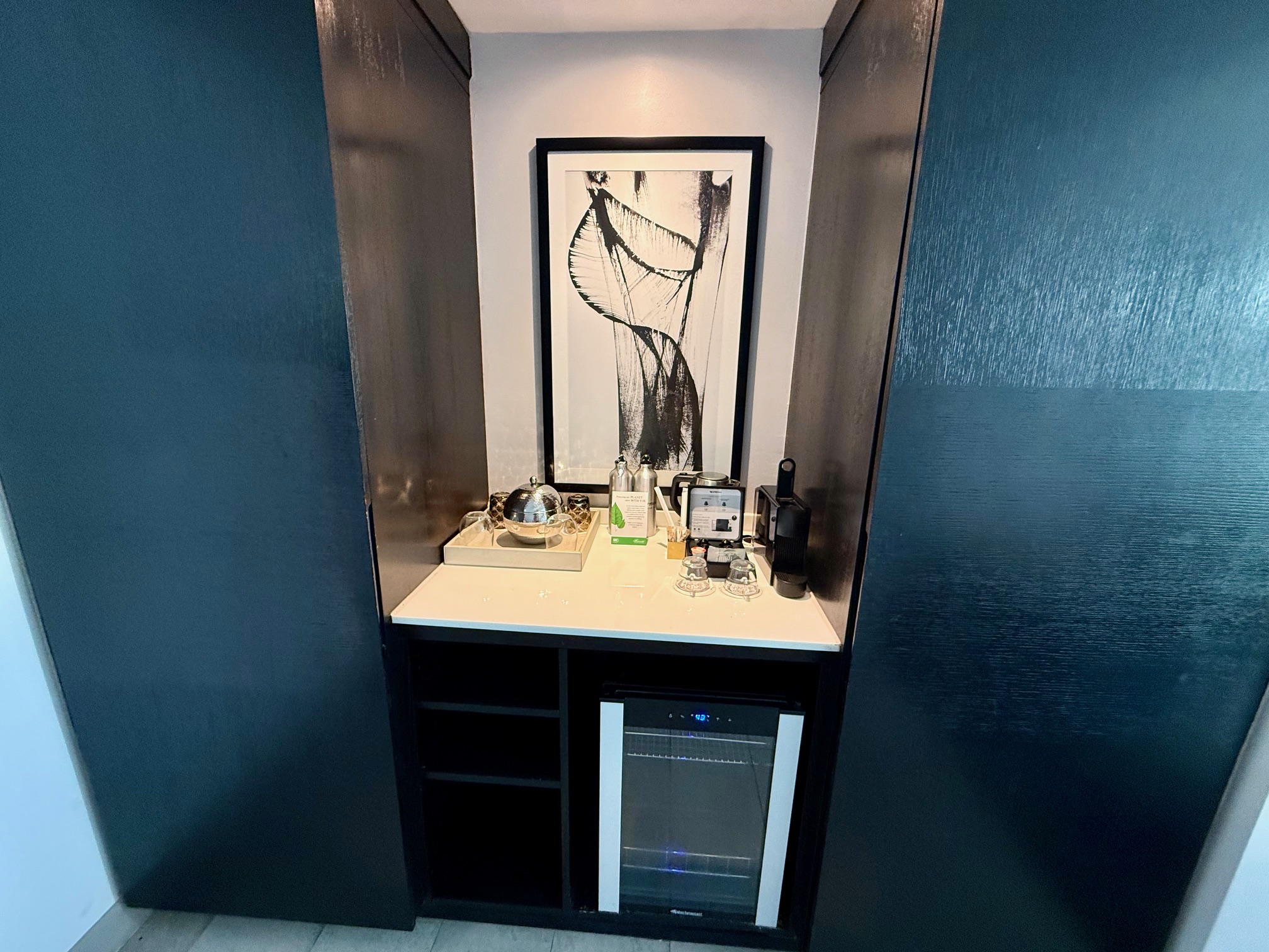 a small kitchen with a microwave and a picture on the wall