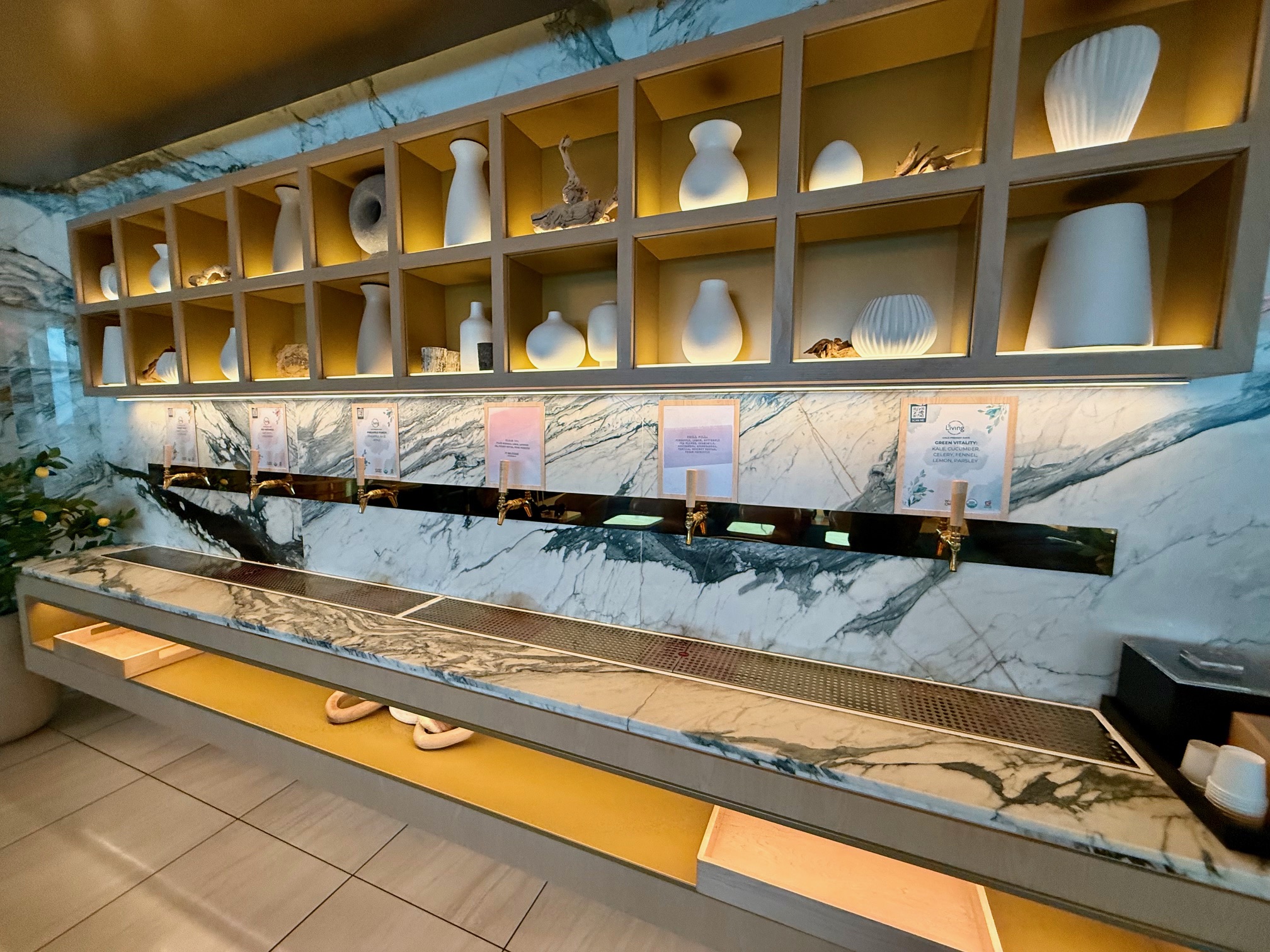 a room with a sink and shelves with vases