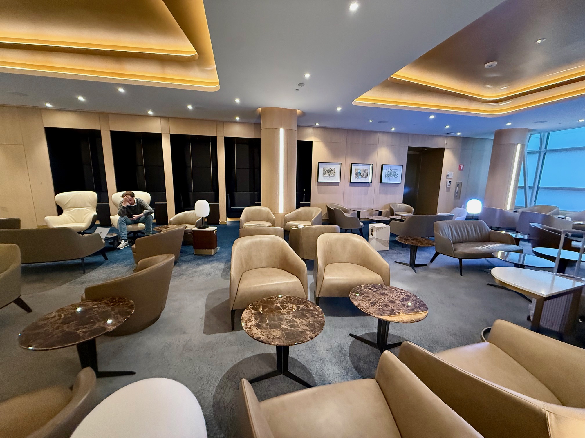 a room with chairs and tables at the Delta One Lounge New York JFK