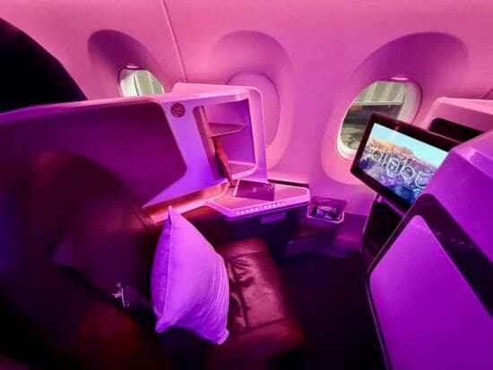 a seat and monitor in a plane on a Virgin Atlantic A350 Upper Class Cabin