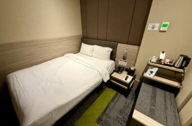 a small hotel room with a bed and a small table at the Aerotel London