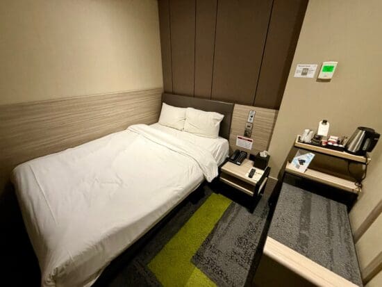 a small hotel room with a bed and a small table at the Aerotel London