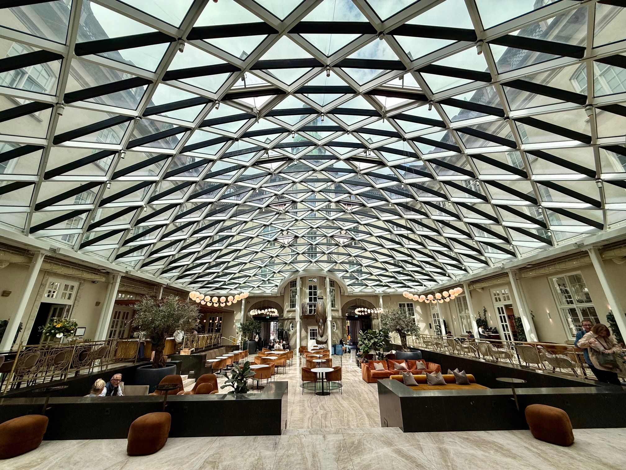 a glass ceiling with a large room with tables and chairs
