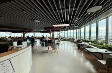 The Eventyr Lounge with tables and chairs and a large window at Copenhagen Airport