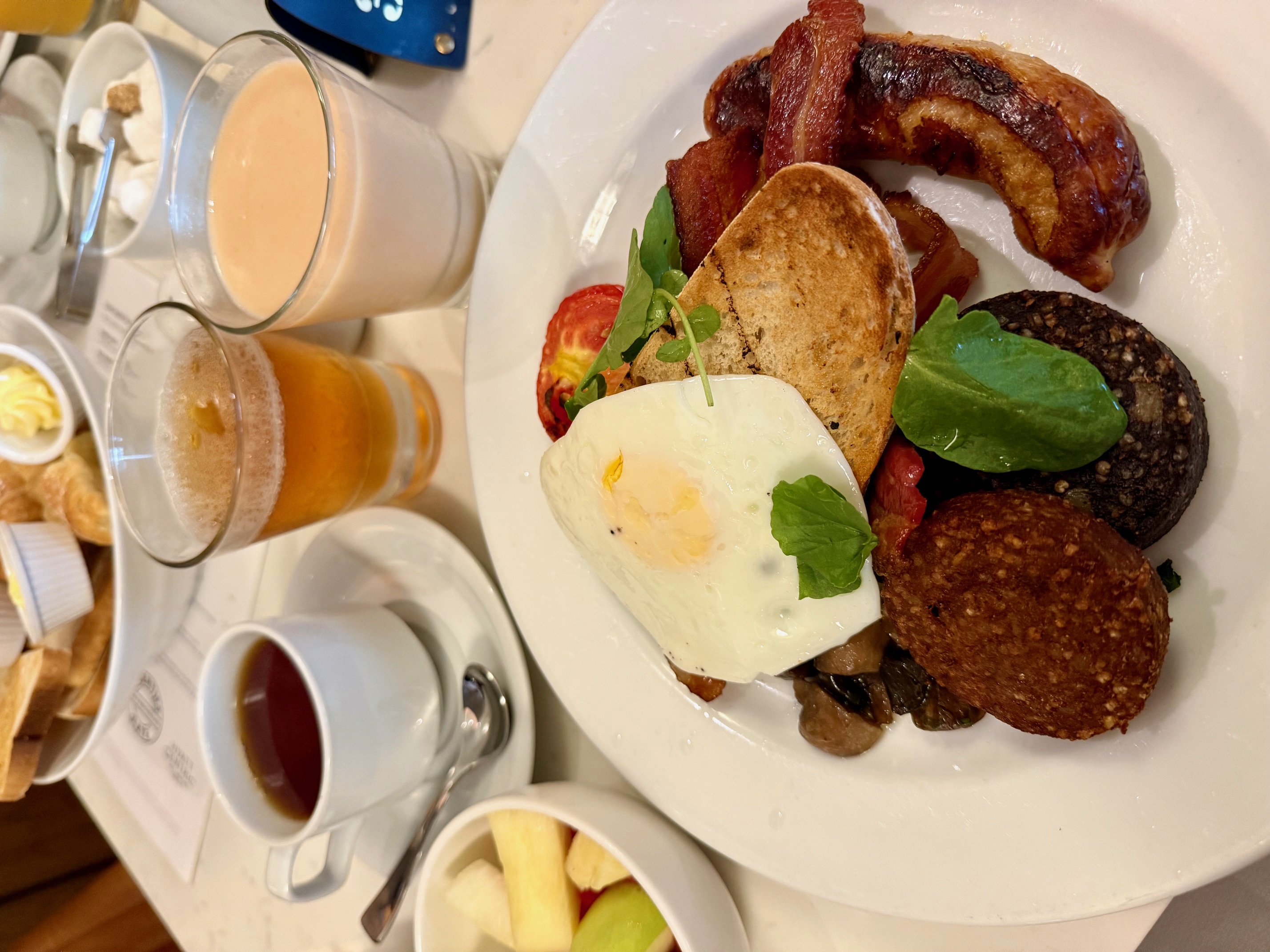 a plate of food next to cups of beer and drinks
