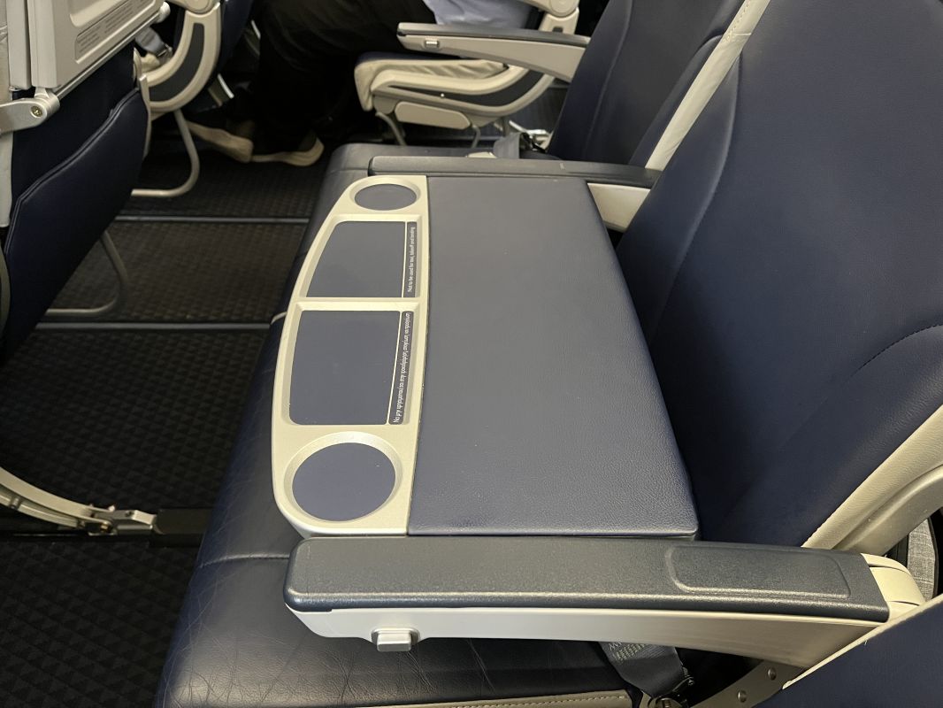 a seat with a grey and white arm rest