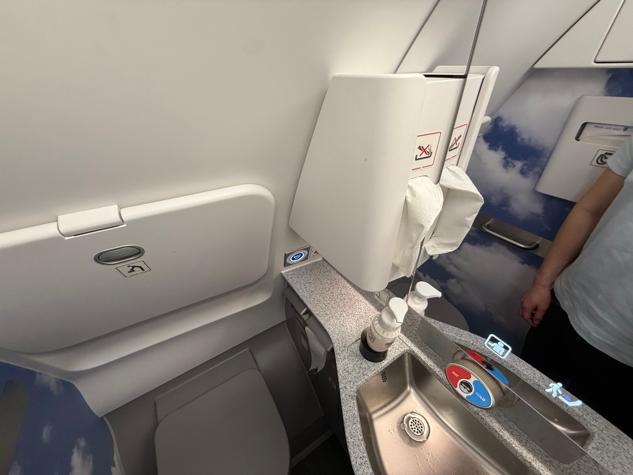 a sink and soap dispenser in an airplane