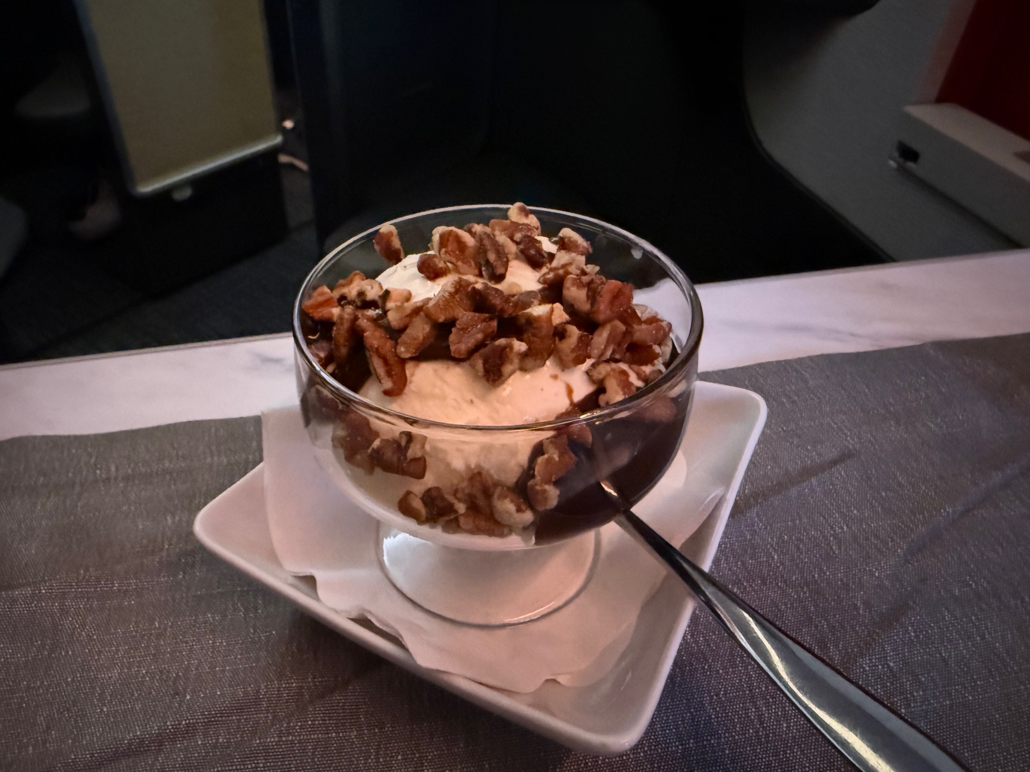a bowl of ice cream with nuts and a spoon