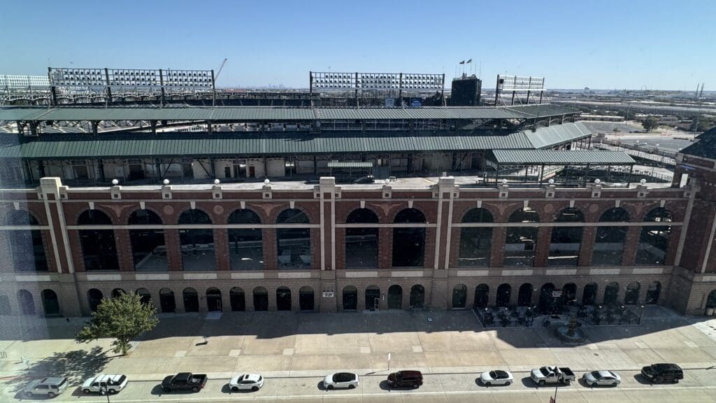 a large stadium with cars parked on the side